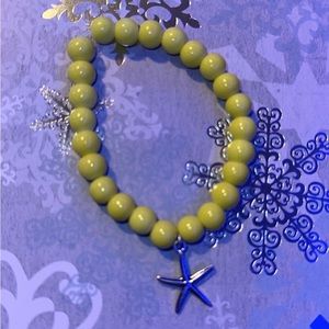 medium light green bracelet with seashell charm attached to the bottom